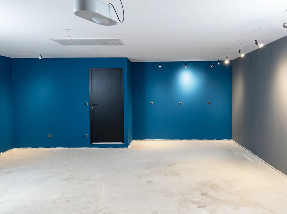 Pièce vide et lumineuse, murs blancs, parquet en bois sombre, plinthe bois ton acajou