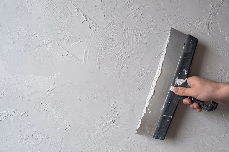 Mur décoratif intérieur présentant un assemblage géométrique de panneaux texturés en relief, créant un motif de losanges alternés avec différentes finitions de surface