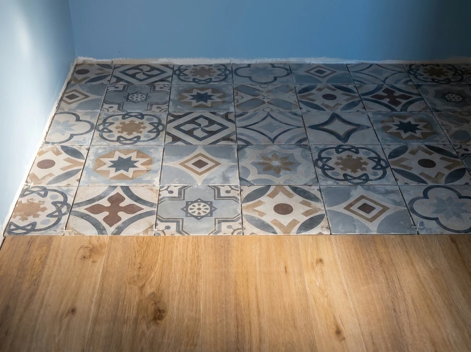 Chantier de carrelage en cours, surface partiellement carrelée avec carreaux de mosaïque bleu turquoise disposés en grille régulière